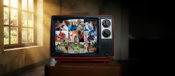 A television screen displays a collage of humanitarian scenes